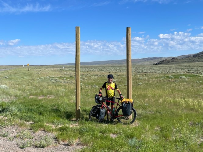 biker in Wyoming with green grass and blue sky